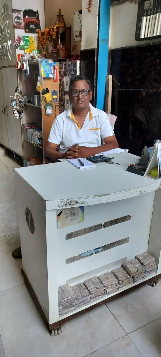 Shanker Lal Gupta, owner of Nitin Plywood House, at the shop counter in Alipur